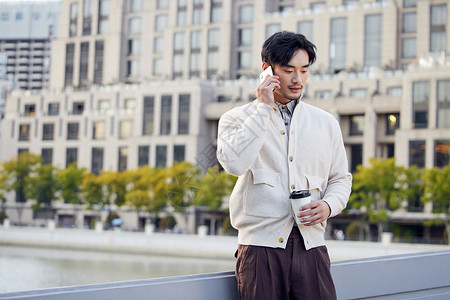 城市街头的成熟男性打电话喝咖啡背景图片