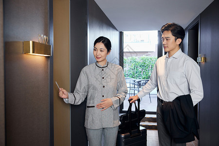 酒店服务人员带领客人房间入住商务装高清图片素材