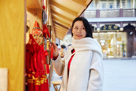 青年女性在庙会采购新年装饰背景图片