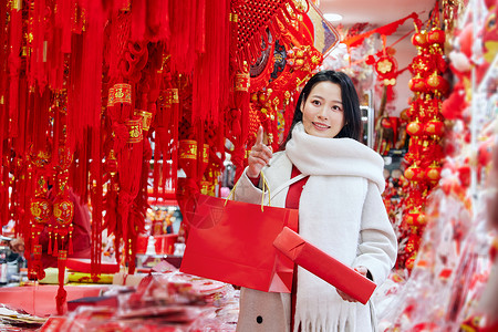 逛年货的女子手拿新年礼物盒背景图片