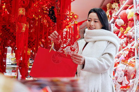 年货店里挑选窗花的女子背景图片