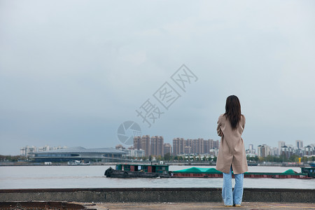 年轻美女站在江边背影冬季高清图片素材