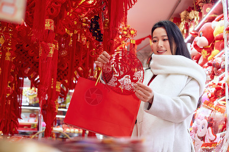 办年货啦年货店里挑选窗花的女子背景