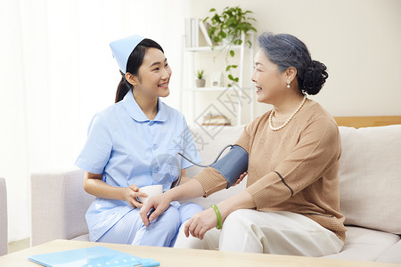 护工帮老年患者测量血压医护人员高清图片素材