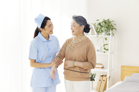 温馨病房年轻女护士照顾关爱老人背景
