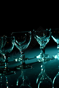 不同的杯子在黑色的深井上蓝色的灯图片