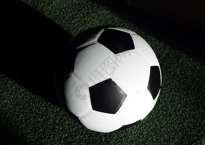 黑色背景草地上的足球背景图片