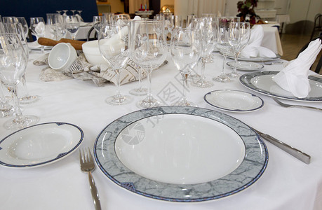 餐桌式圆形餐厅配有带盖的菜肴和玻璃杯图片