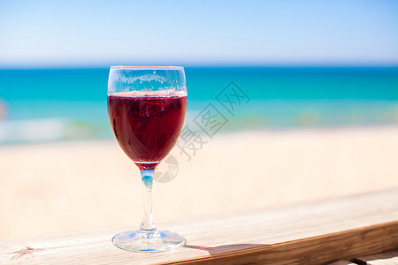 杯红葡萄酒反对绿松石海图片