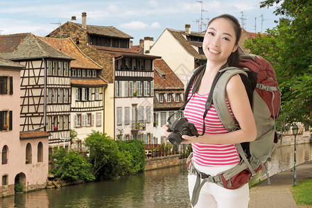 微笑旅行的亚洲女孩拿着相机在欧图片
