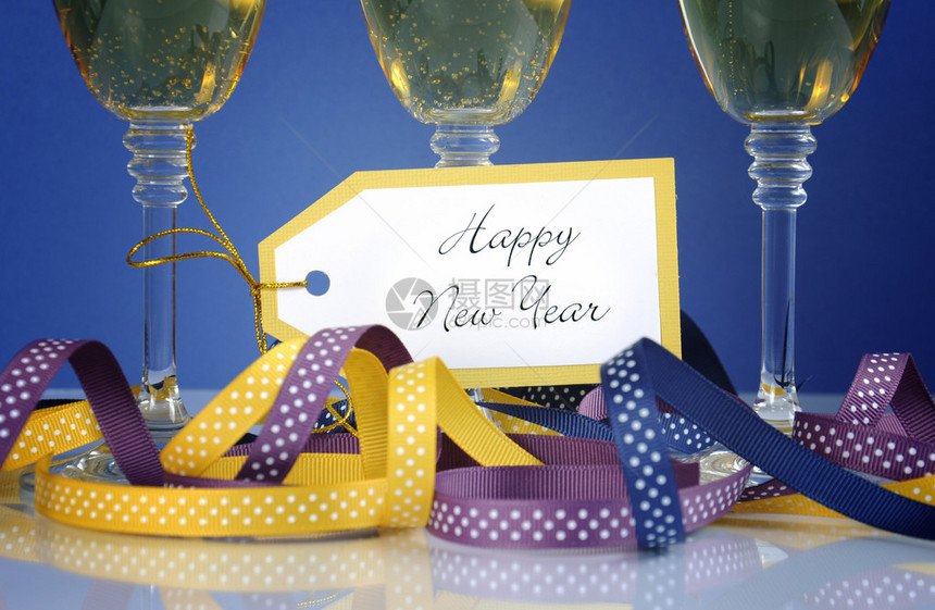 以三杯香槟杯子派对彩带和装饰品来关闭新年快图片