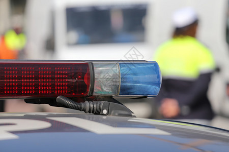 红色和蓝色警报器警车在有穿制服警图片