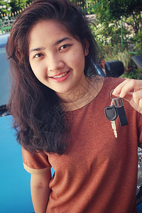 拿着新车钥匙的年轻女人背景图片