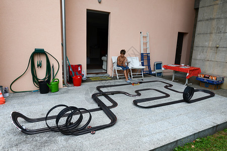 男孩在花园里玩赛车跑道图片
