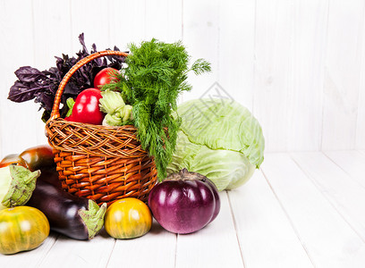 篮子里的新鲜水果堆和木制背景上的蔬菜图片