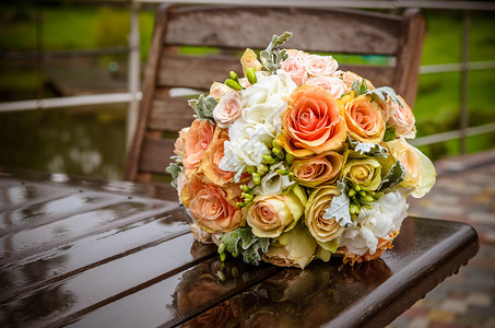 雨后湿木桌上的婚礼花束图片
