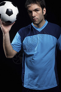 蓝色制服的足球运动员有球的背景图片
