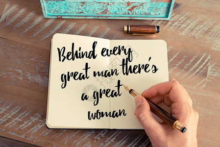 女人手写在笔记本上的复古效果和色调图像手写的报价每个伟人背后都有一个伟大的女人作为鼓舞人背景图片