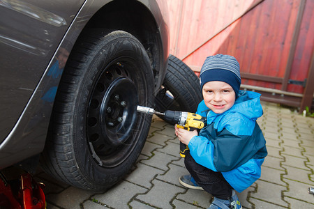 小男孩用冬天的轮胎换夏天图片