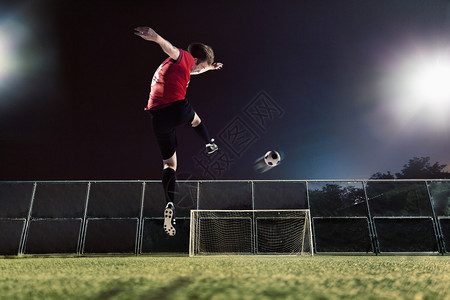 运动员将足球踢向球门图片