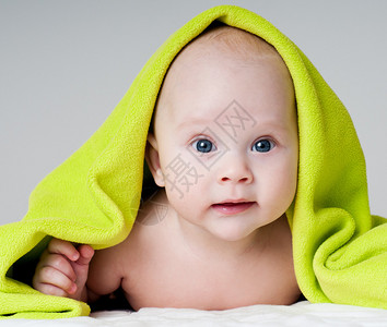 洗完澡后用毛巾裹着美丽的快乐婴儿图片
