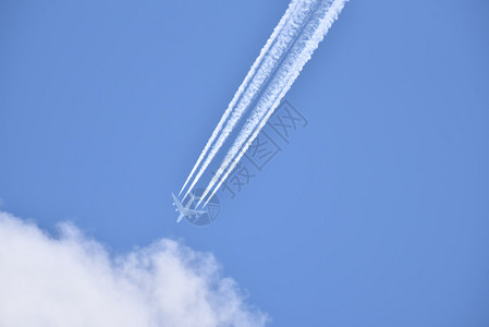 白色客机在蓝色云天拉扯白甲状物图片