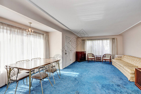 工匠风格的内饰入口房间与用餐区相连复古家具六人餐桌和蓝色柔软的地毯板图片