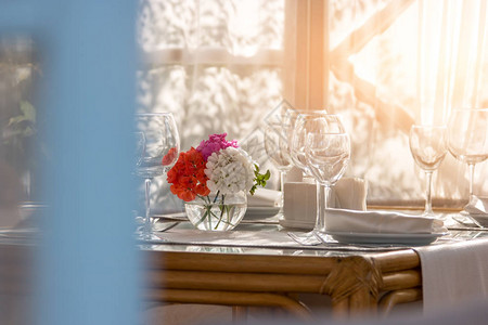 餐桌上的鲜花盘子和空酒杯邀请你的亲戚吃早餐完美图片