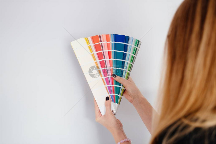 从色调色盘中选择墙颜色的女设图片