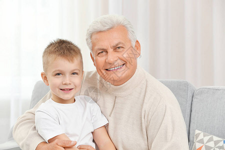 有孙子在沙发上的快乐祖父图片