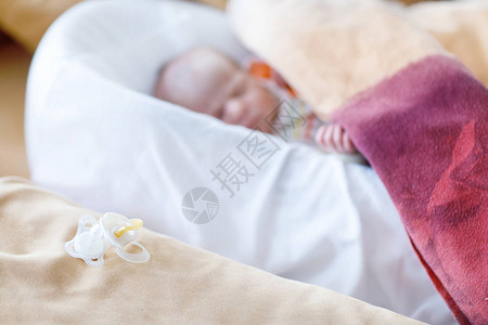 可爱的新生婴儿在床上安静地睡着专注于平静的奶嘴或假奶嘴新出生的孩子图片