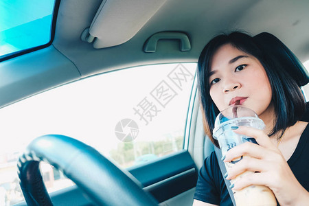 妇女在乘车旅行时喝着冰图片