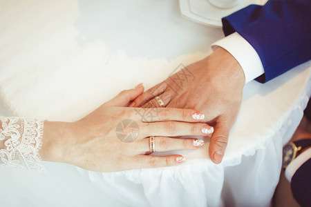 新娘和新郎的手粉红色的结图片