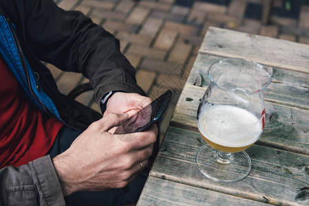 坐在酒吧喝啤酒时男人在图片