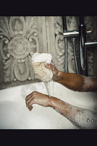 美丽的沐浴女人用海绵清洁自己图片