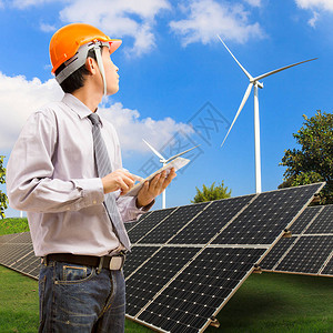 使用数字平板机的工程师在工业太阳能发电和风力涡轮机上工图片