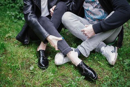 坐在地上公园里的情侣的腿图片