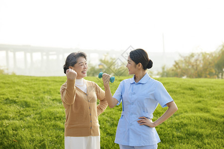 老人运动哑铃户外年轻女护工指导老人康复背景