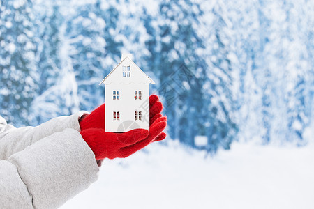 小房子装饰雪地里手拿白色小房子特写背景