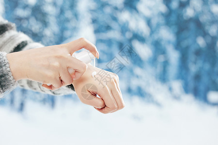 冬日里女子使用护手霜特写图片