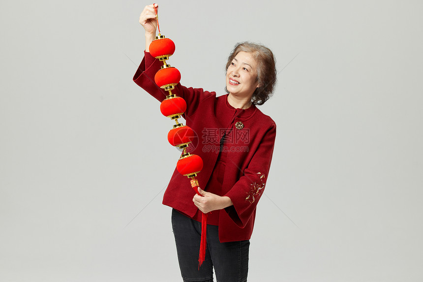 手拿春节挂饰的新年老奶奶图片