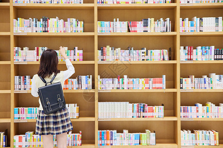 在图书馆里找书的女学生背影背景图片