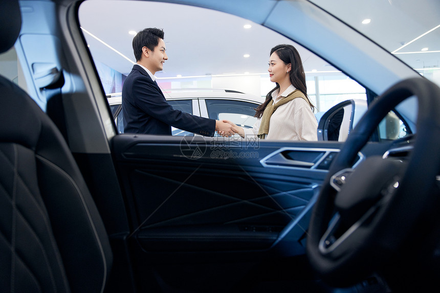 女顾客与汽车销售握手成交图片
