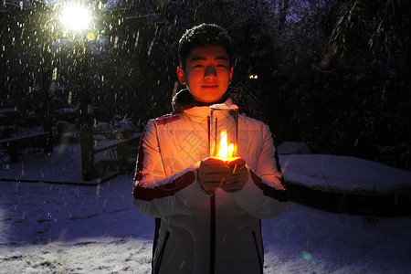 拿着蜡烛的男孩男孩在院子里手捧小台灯背景