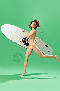抱腿看书女孩兴奋的青年女人抱着冲浪板奔跑背景