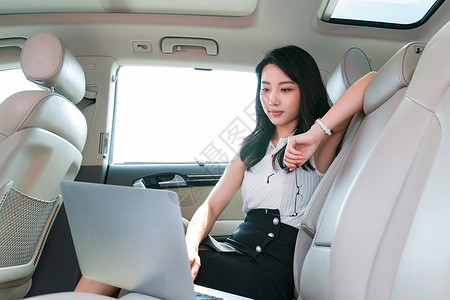 商务女在汽车内使用笔记本电脑图片