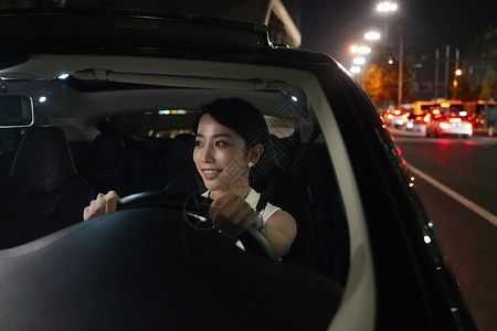 晚上漂亮的年轻女人开车汽车高清图片素材