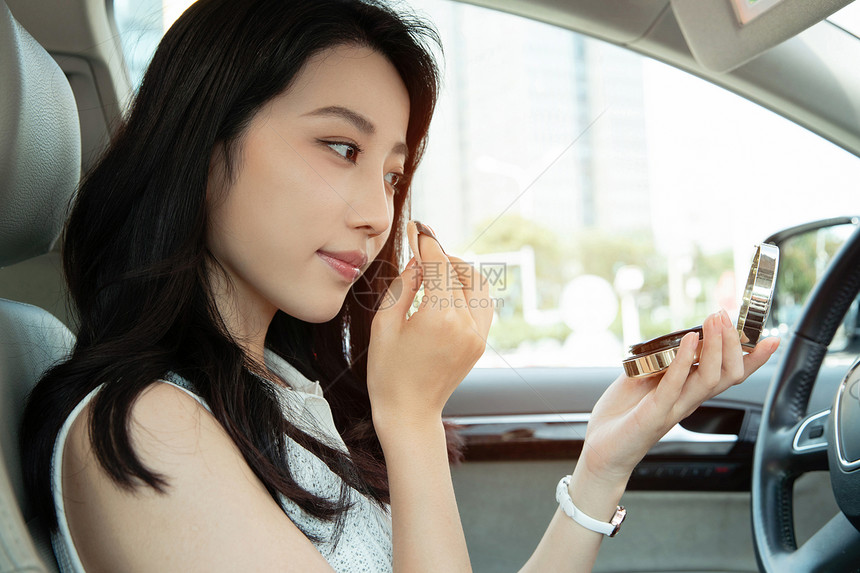 青年女人坐在车里化妆图片