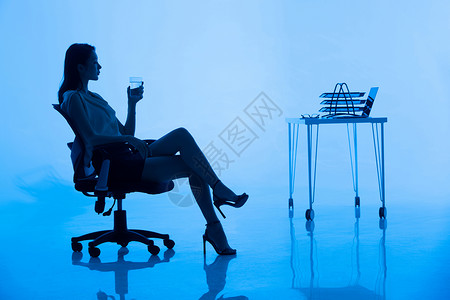 酒杯剪影办公室里喝水的商务女士背景