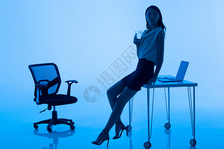 成功人士剪影商务女士在办公室里喝水背景